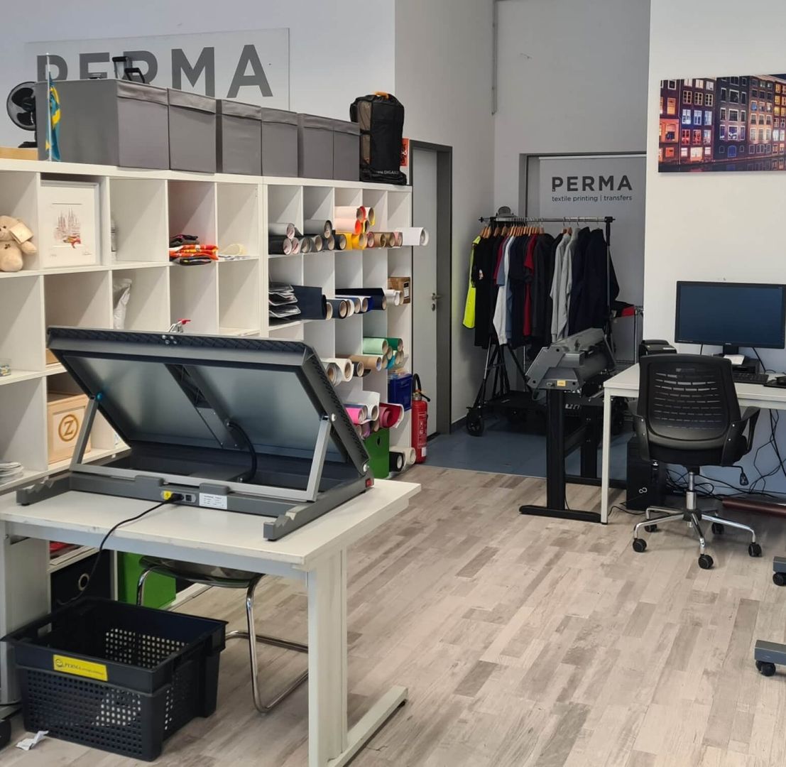 Perma GmbH workroom - A room with a desk, a computer and a textile printer.